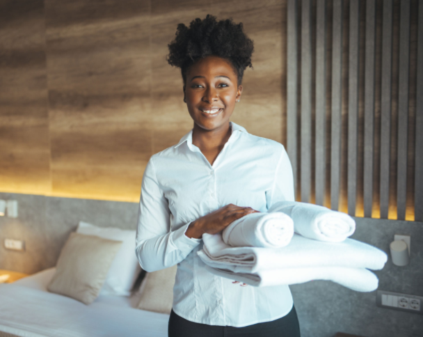 a housekeeping manager holding towels after completing a room inspection