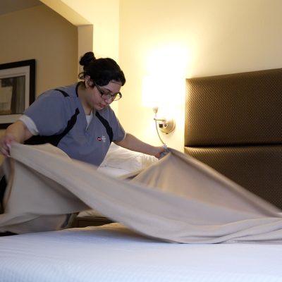 a hotel housekeeper making a bed